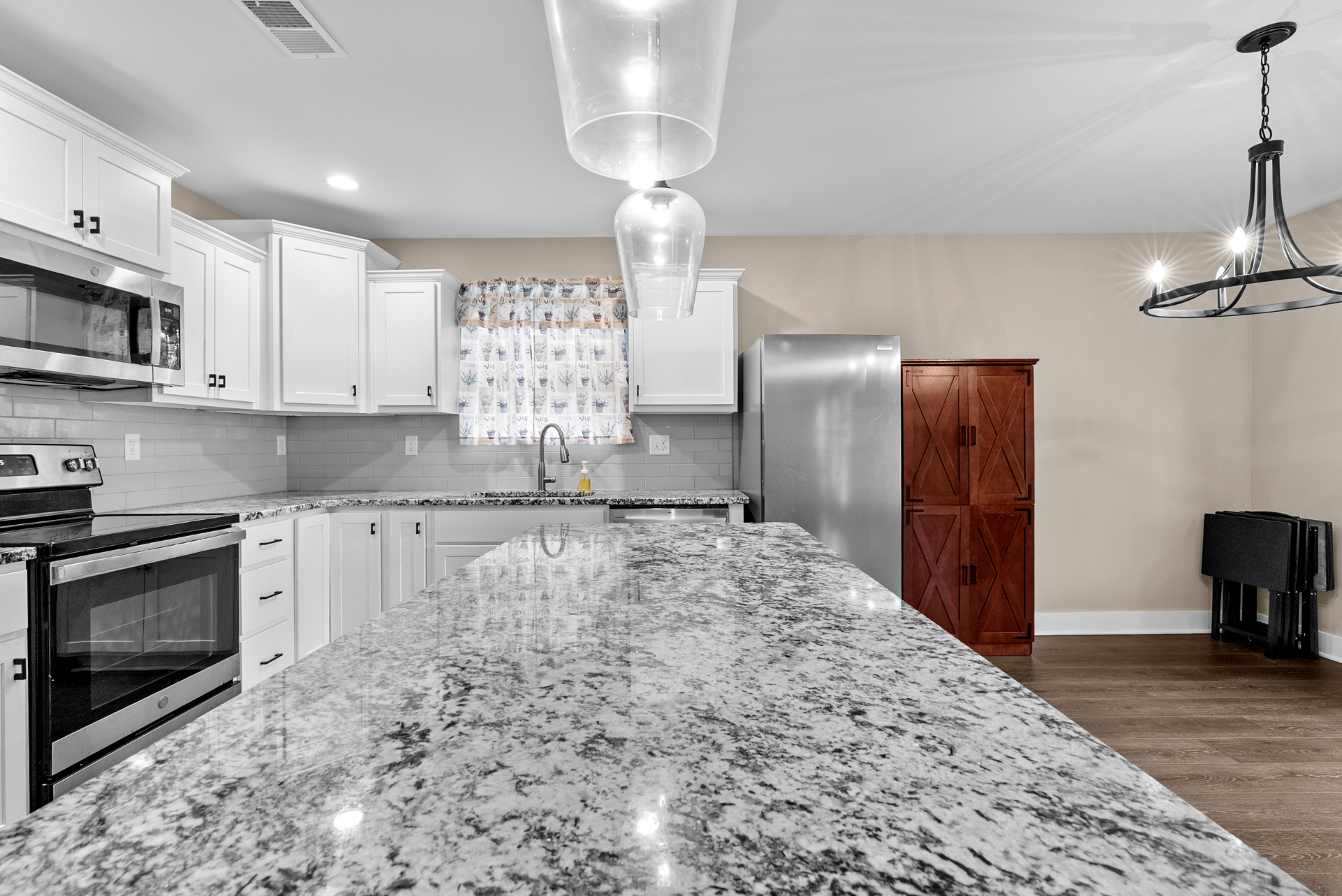 Kitchen with granite, subway tile, and pendant lighting